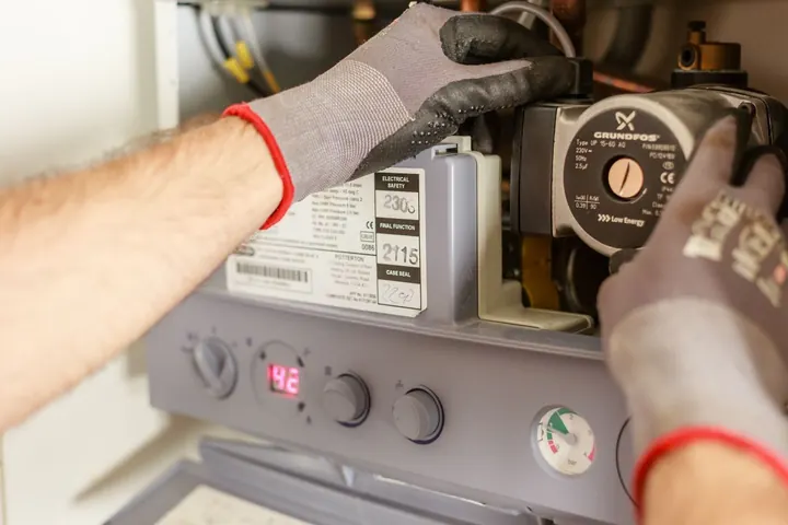 Hands adjusting a water heater control, water heater installation Fort Myers